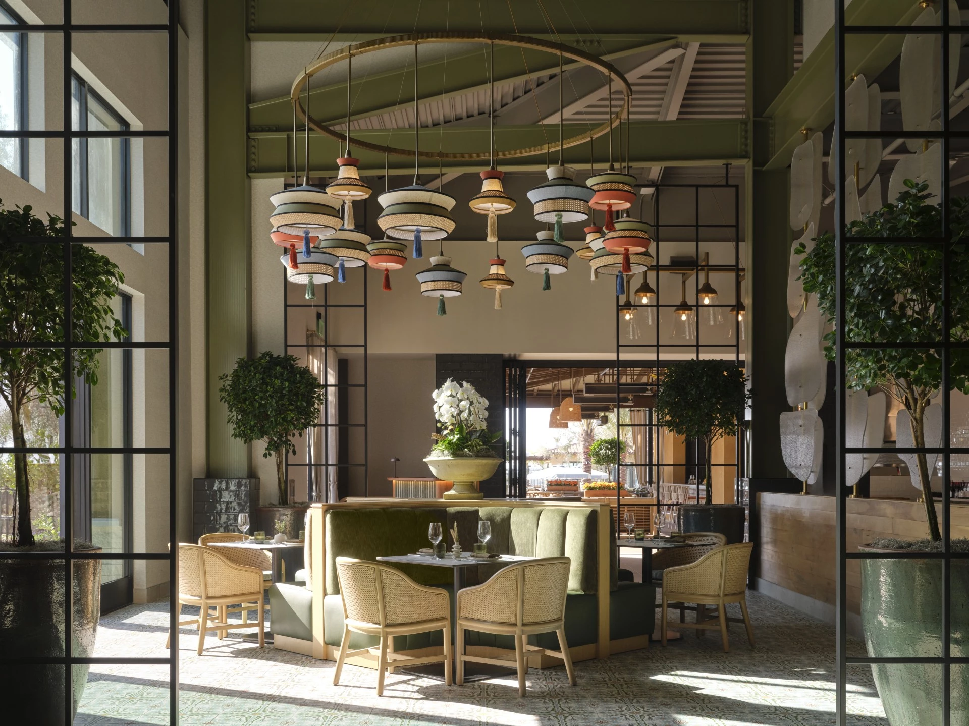 a room with a chandelier and tables and chairs