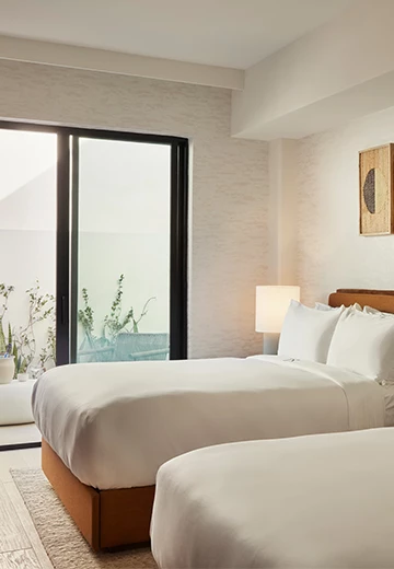 a room with two beds and a glass door