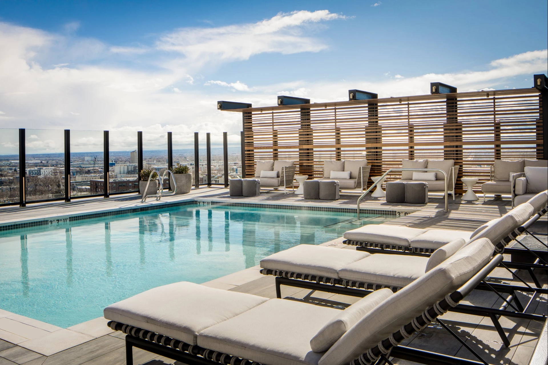 a pool with lounge chairs and a city view