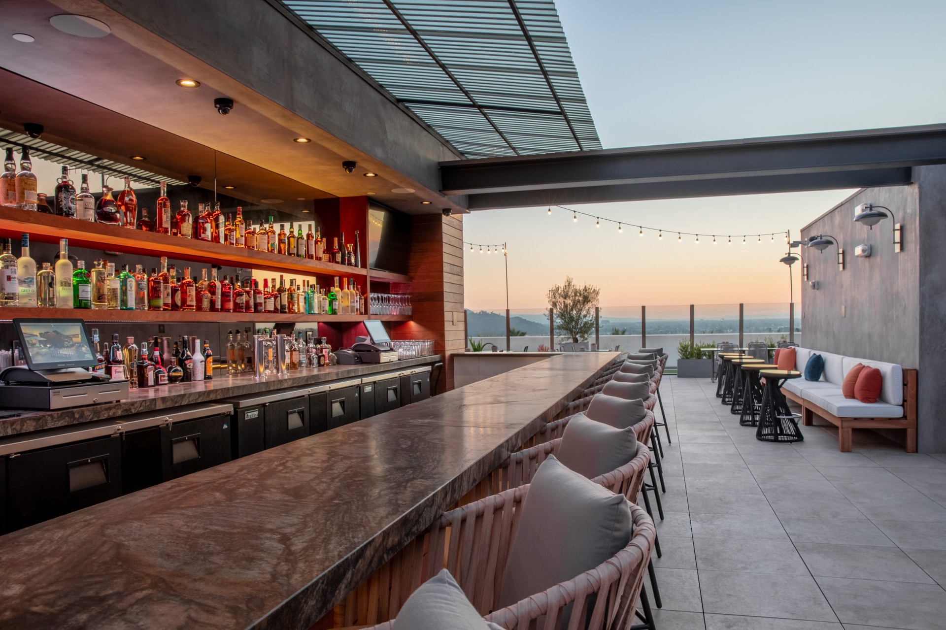 a bar with chairs and a table with drinks