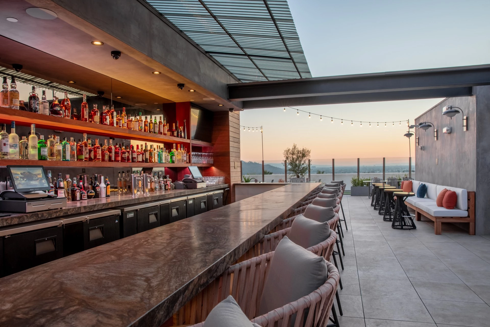 a bar with chairs and a table with drinks