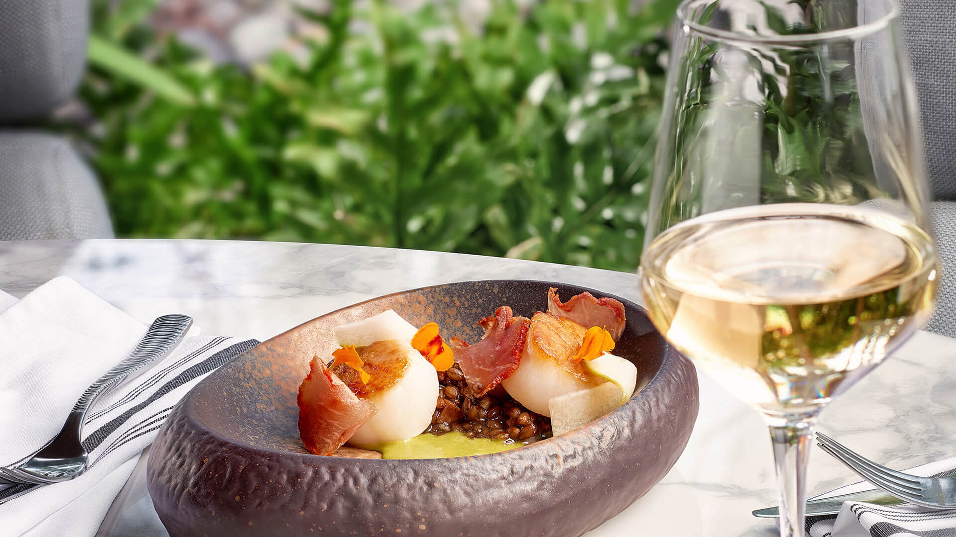 a plate of food and a glass of wine Next