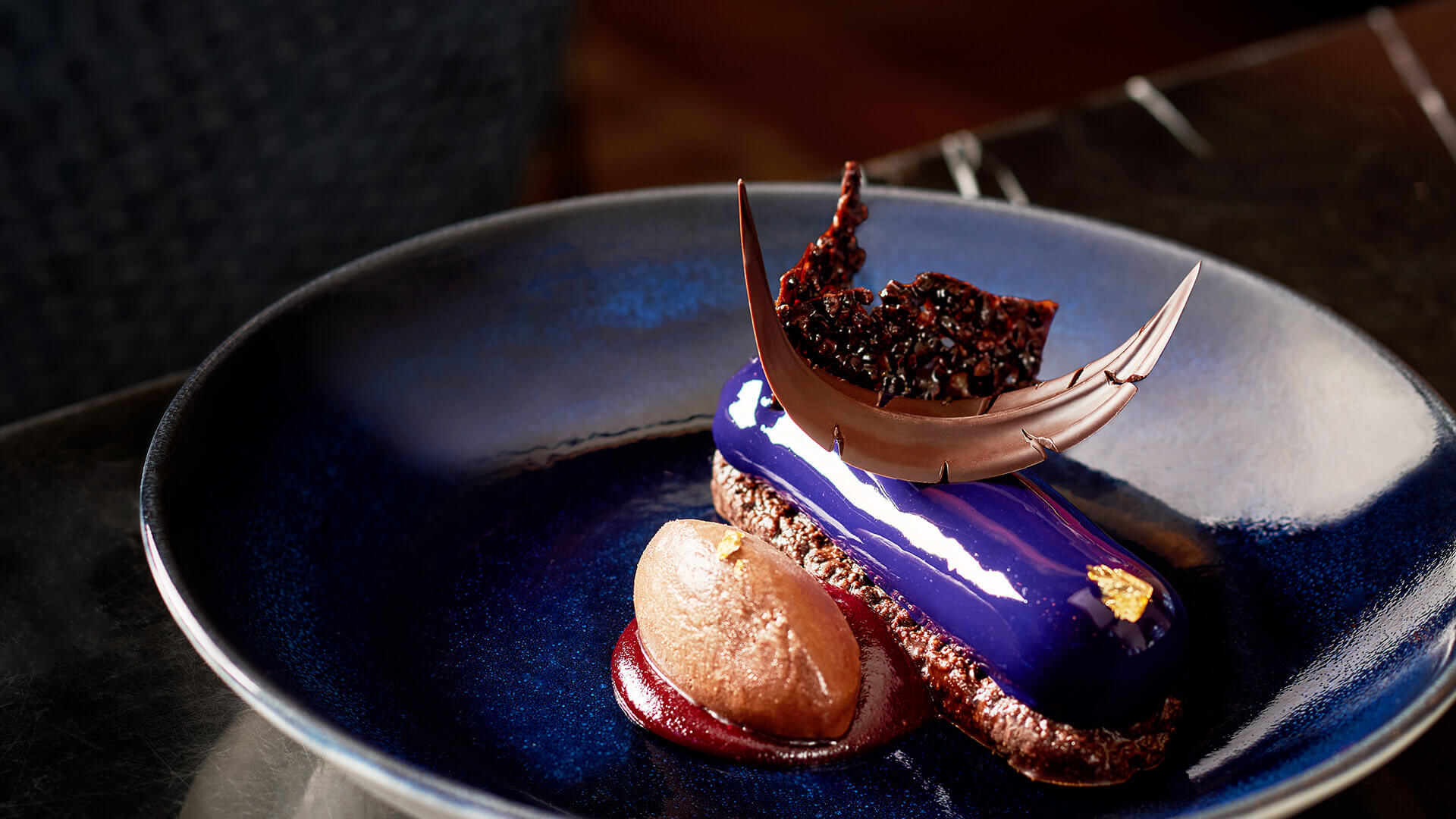 a blue plate with a chocolate and a piece of dessert