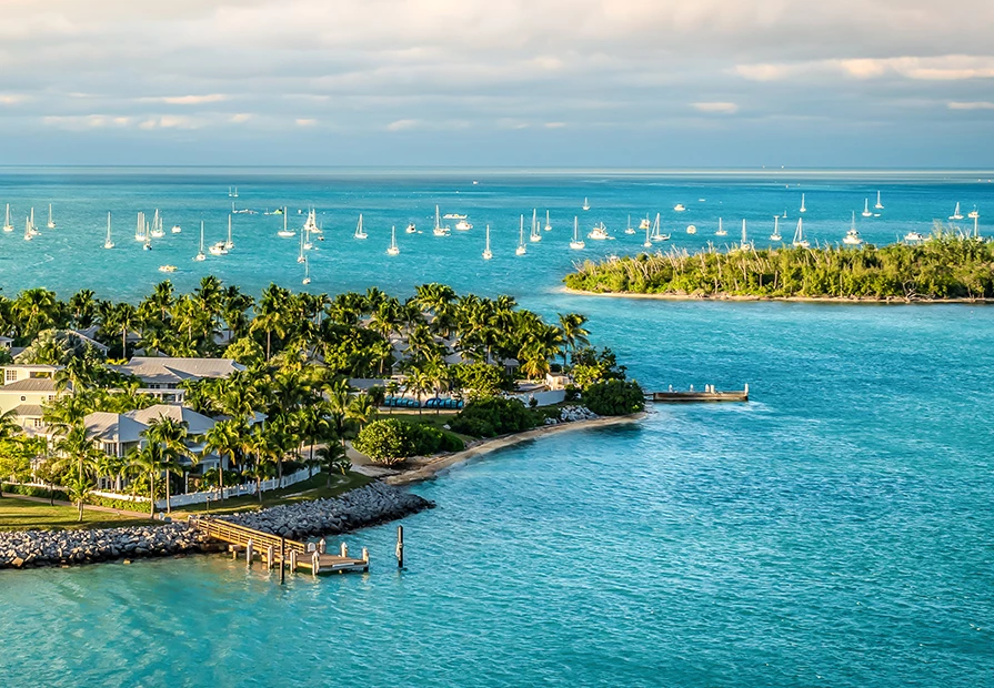 aerial image of water and land with sailboats in the background