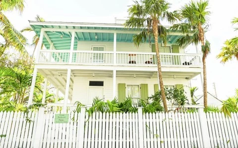 Main house with palm trees in front of it 