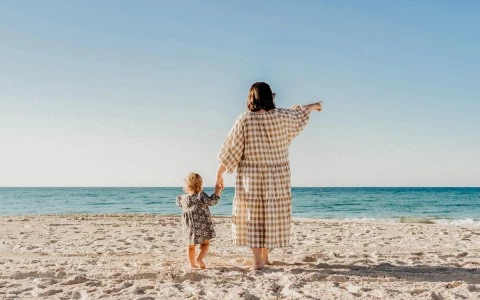 a woman and a baby on the beach