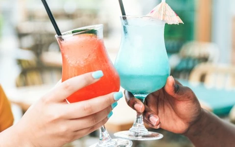 two people clinking cocktails together