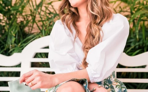 a woman wearing a white blue sitting on a white bench