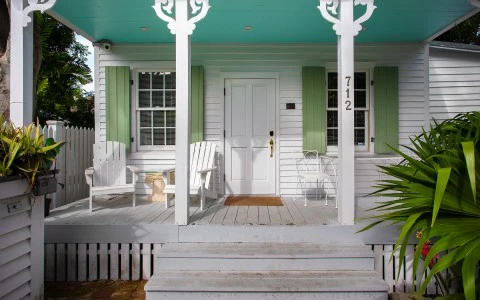 front side of white house with some plants