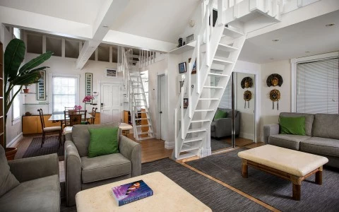 living room with some sofas and white stairs