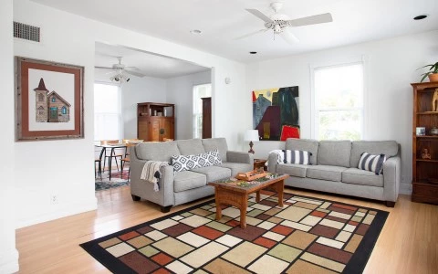 living room with a color full carpet and gray sofas