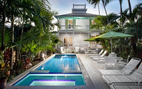 front view of a two floor house and a swimming pool
