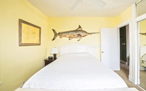 bedroom with yellow walls and a fish over the bed 