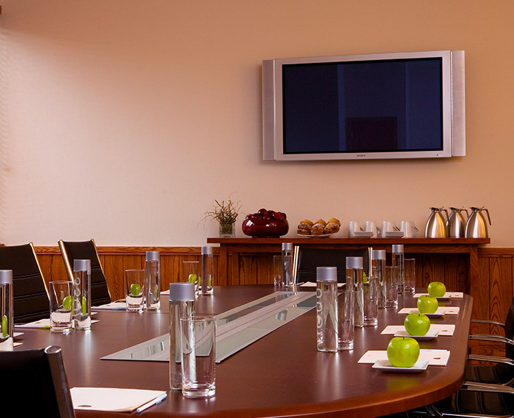 meeting room with large brown table and a hanging tv