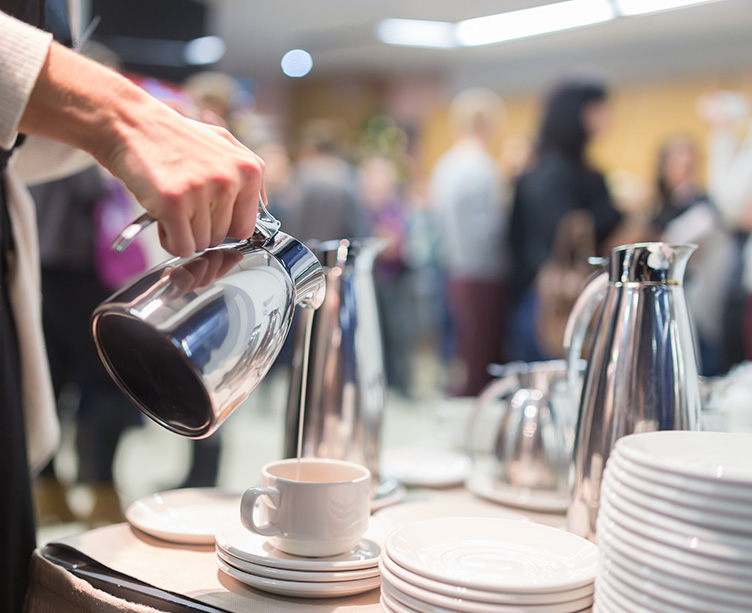 waiter filling a cup of milk