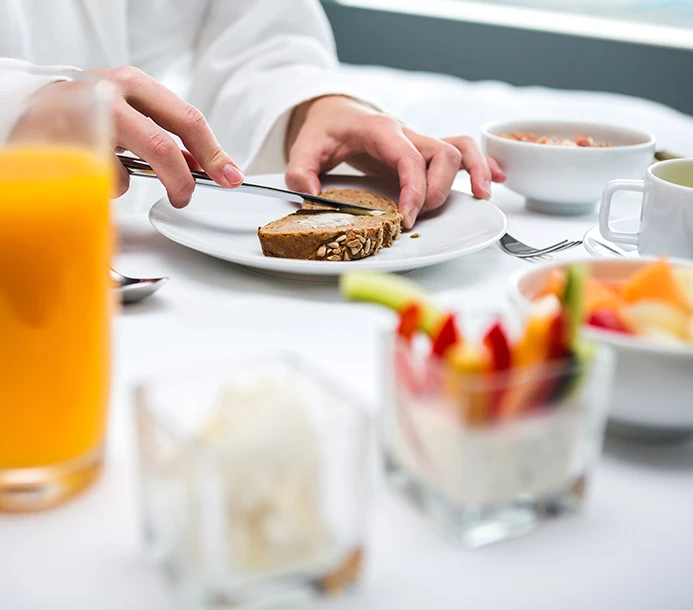 man cutting a piece of bread with breakfast