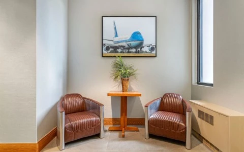 two chairs in a room with a picture on the wall