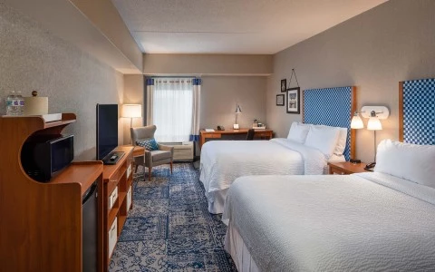 view of 2 double bed accommodations with sitting area and desk