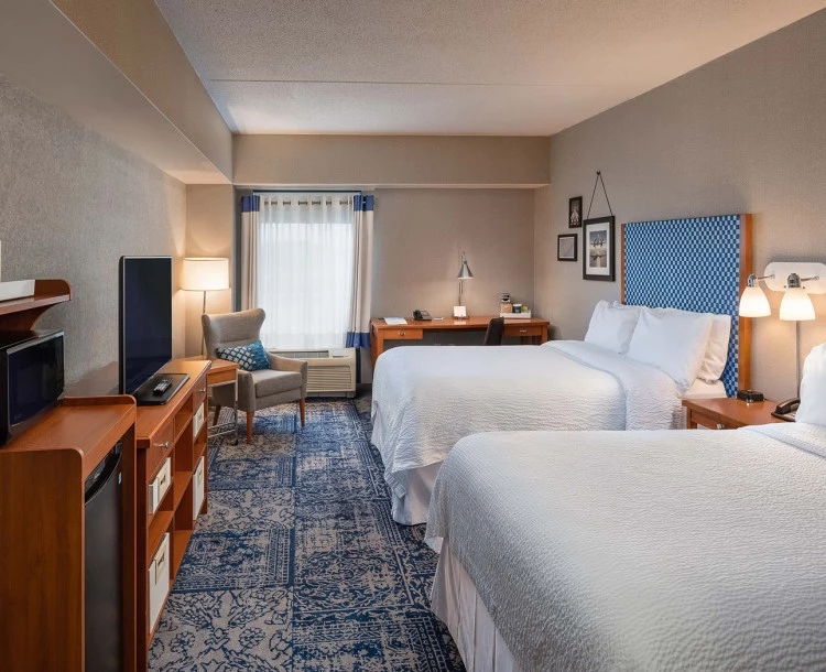 corner view of a double bedroom of property in gray and pale accents