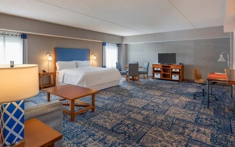 view of spacious accommodations with King Bed, sitting area, dining area, and desk