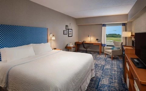 view of king bed accommodations with view of airport runway