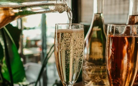 rose champagne bottle filling a glass up