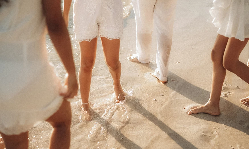 a group of people walking on the beach