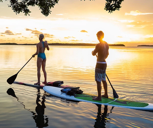 a man and woman on a paddle board