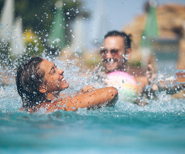a couple of people swimming in a pool