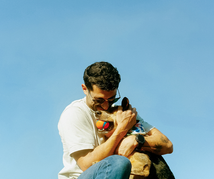 a man holding a dog with a ball