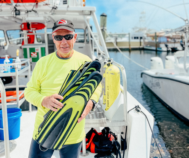 a man holding flippers on a boat