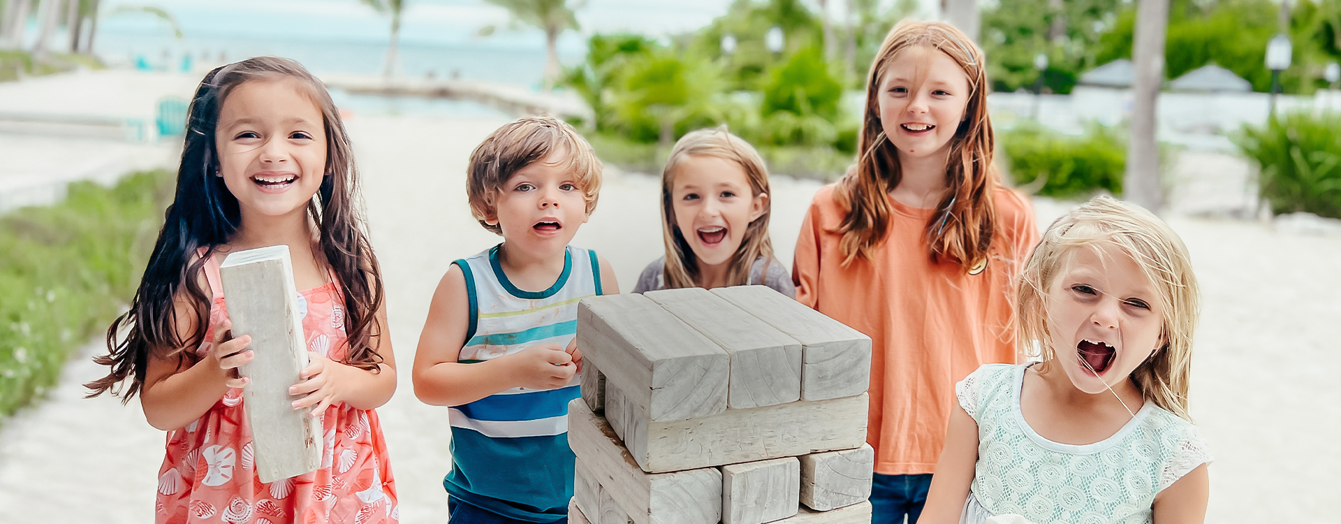 a group of kids playing with a stack of wood blocks