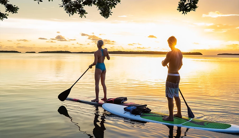 a man and woman on a paddle board