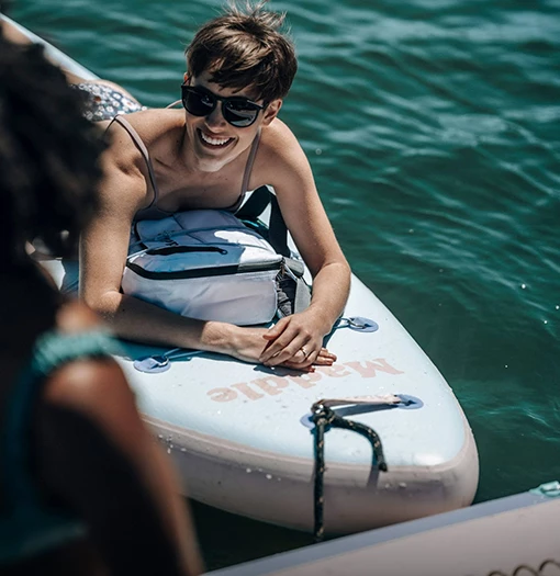 a woman lying on a surfboard in the water