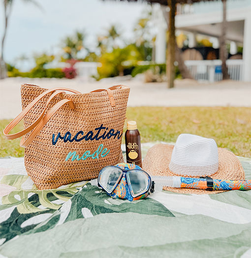 a beach bag and hat on a blanket