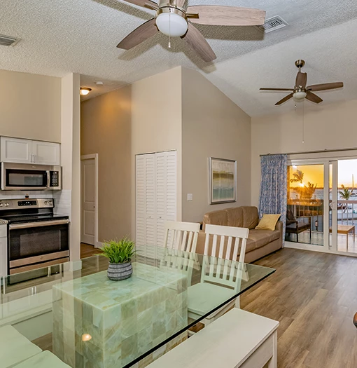 a living room with a glass table and a ceiling fan