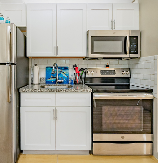 a kitchen with white cabinets and a microwave