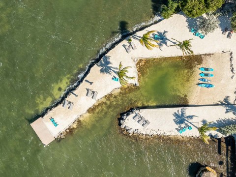 a dock with chairs and a pool in the water