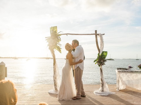 a man and woman kissing on a dock
