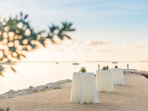 a group of tables with white cloths on the side of the table