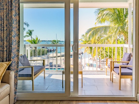 a sliding glass door to a room with a view of the ocean and a beach