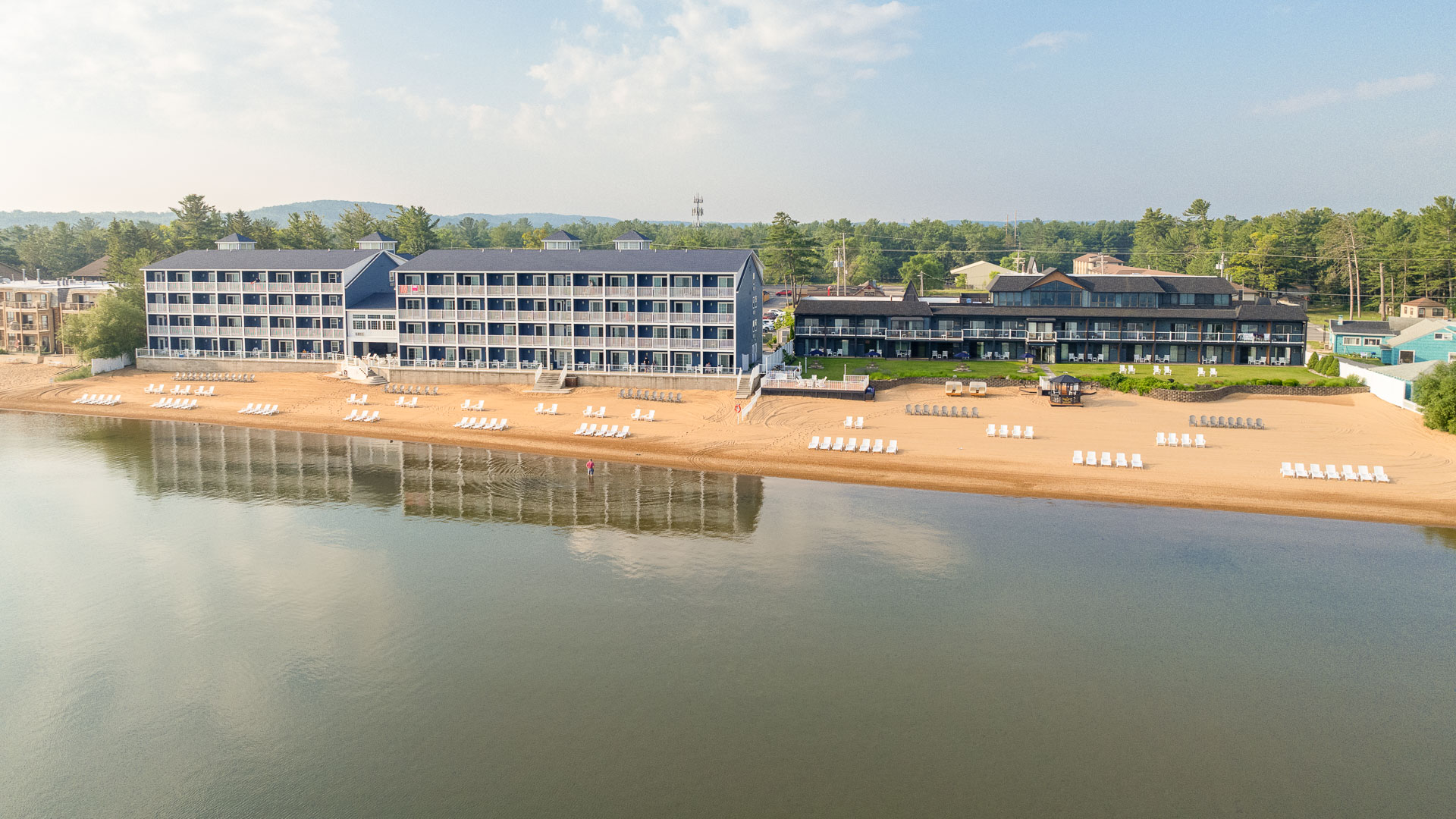 A large hotel complex with a beach and water view.