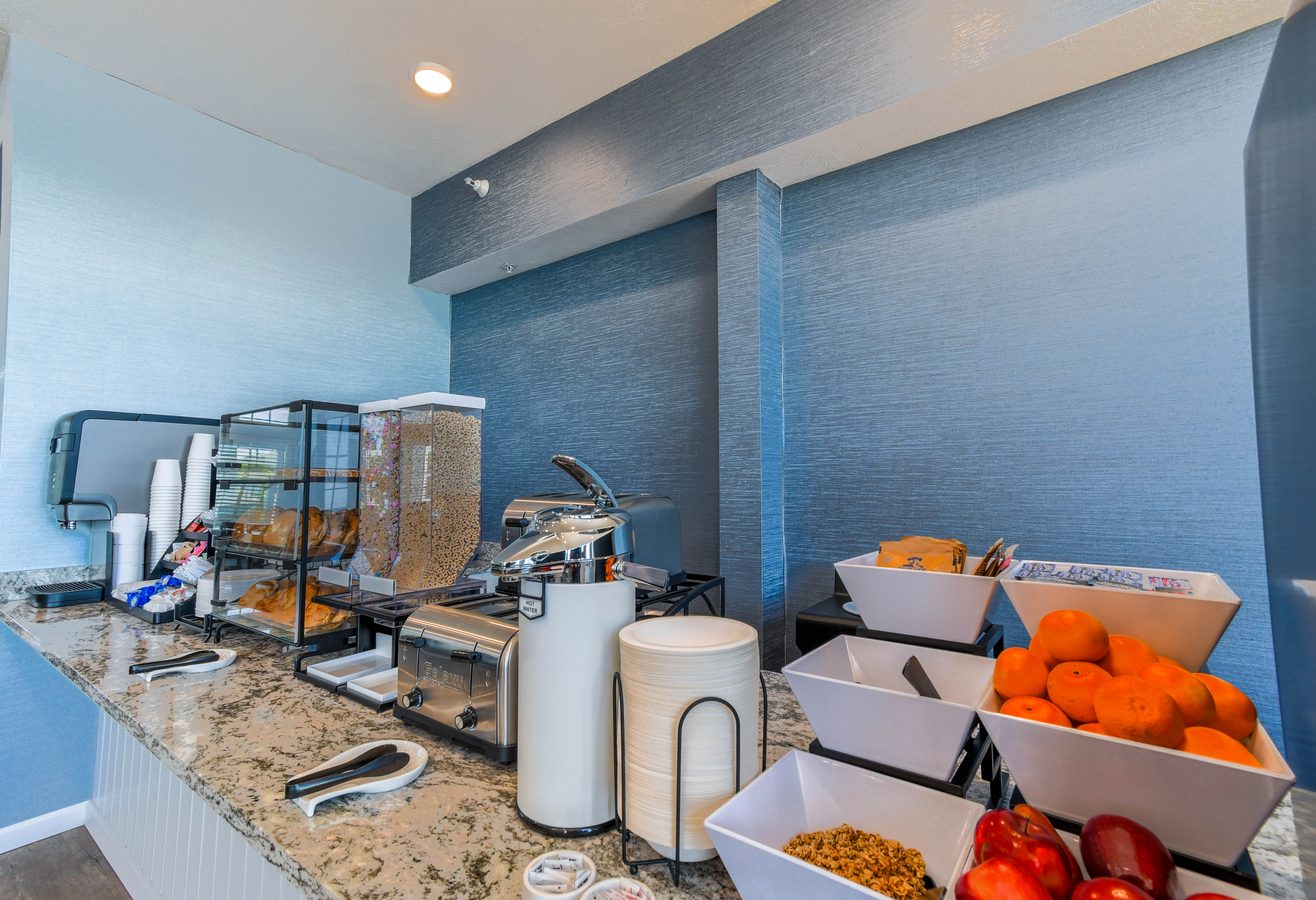 A breakfast buffet with a variety of foods and fruits