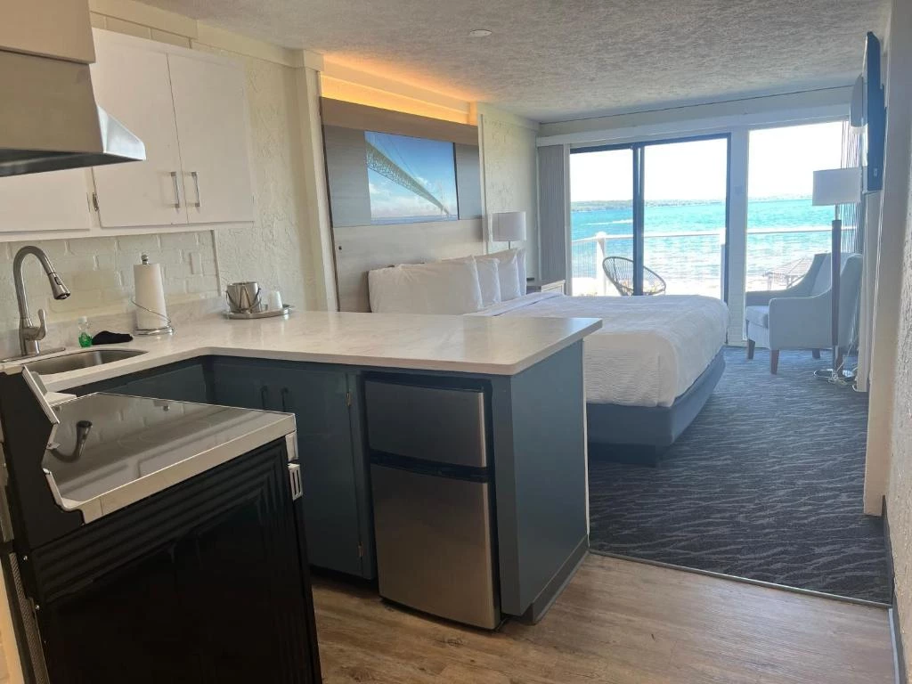 a room with a bed and a kitchen