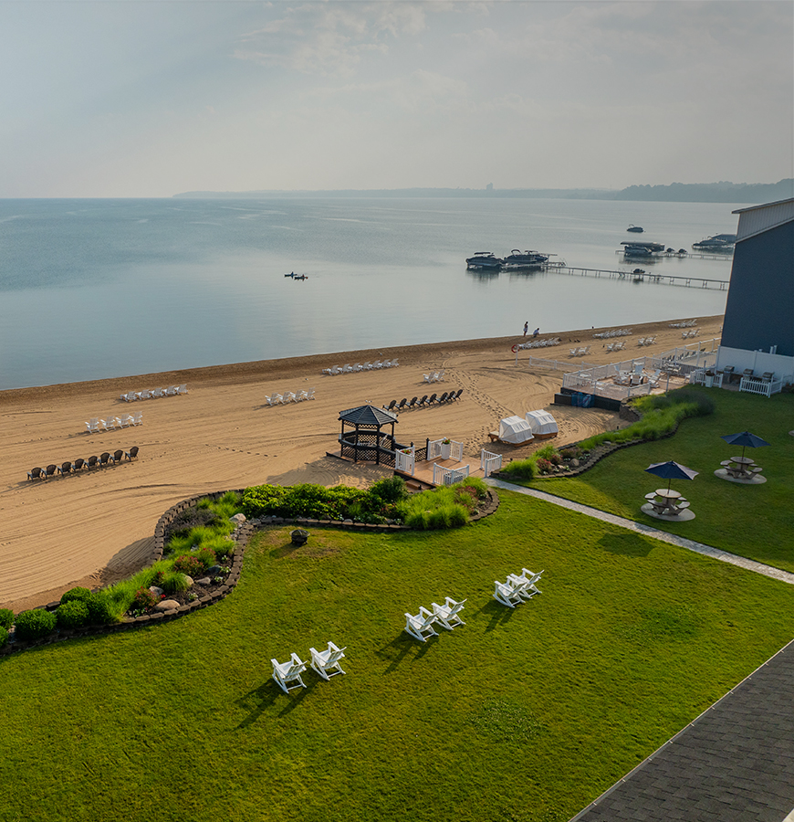 Aerial view of a beach with a lawn and pier