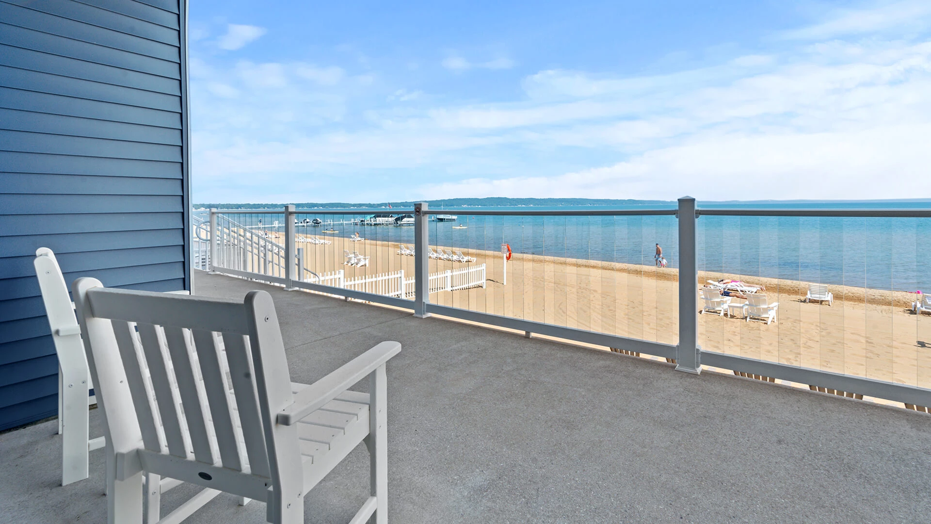 a white chair on a deck overlooking a beach