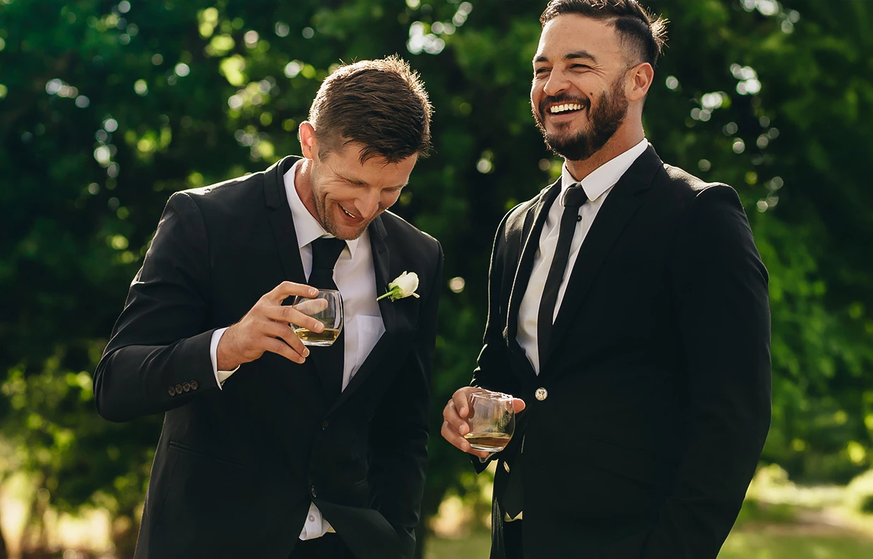 two men in suits holding drinks