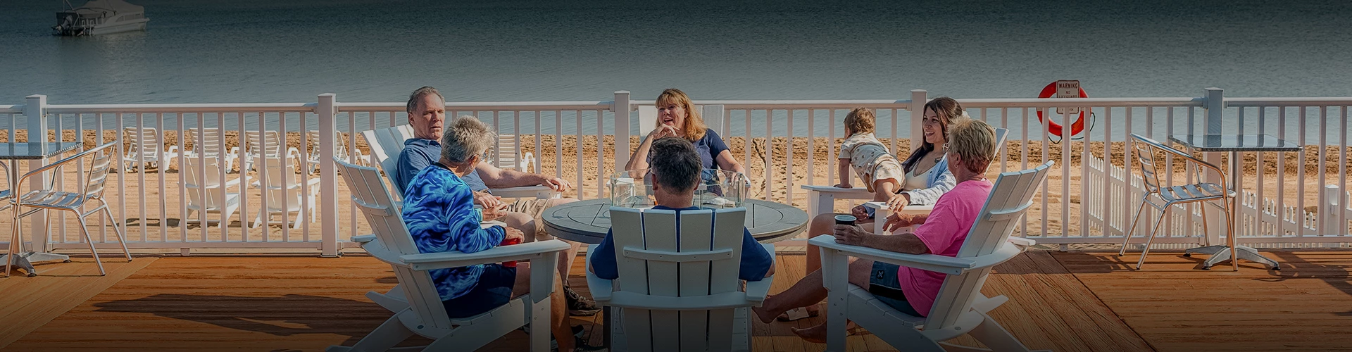 a group of people sitting at a table on a deck