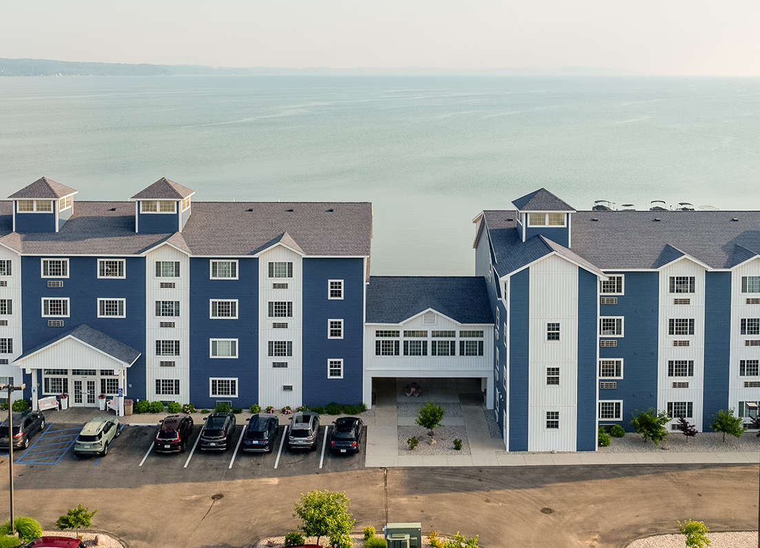 a building with a parking lot and a body of water