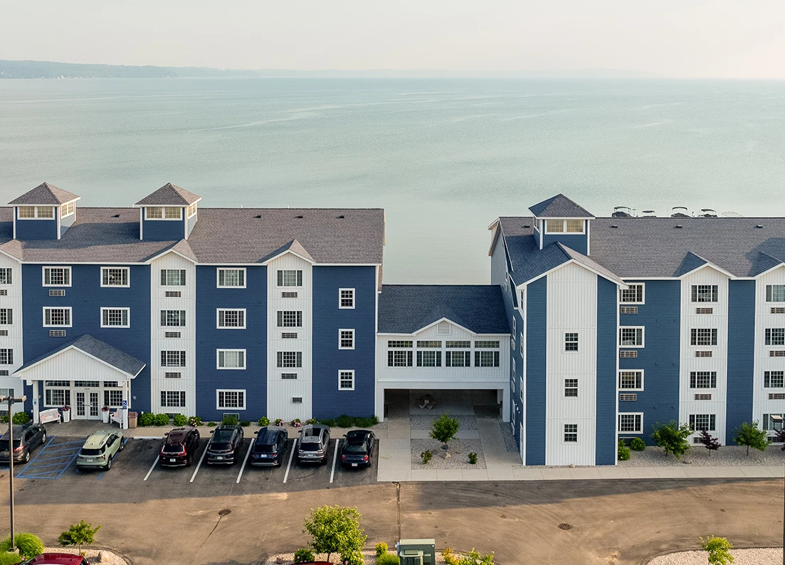 a building with a parking lot and a body of water